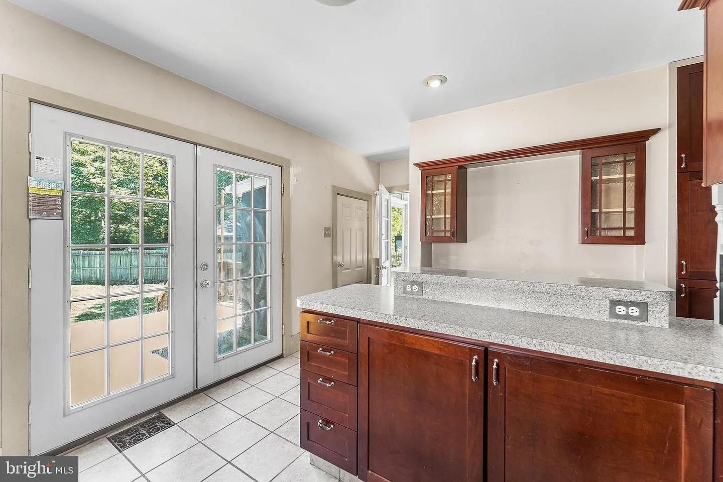 Kitchen with cherry cabinetry, granite countertops, and breakfast bar