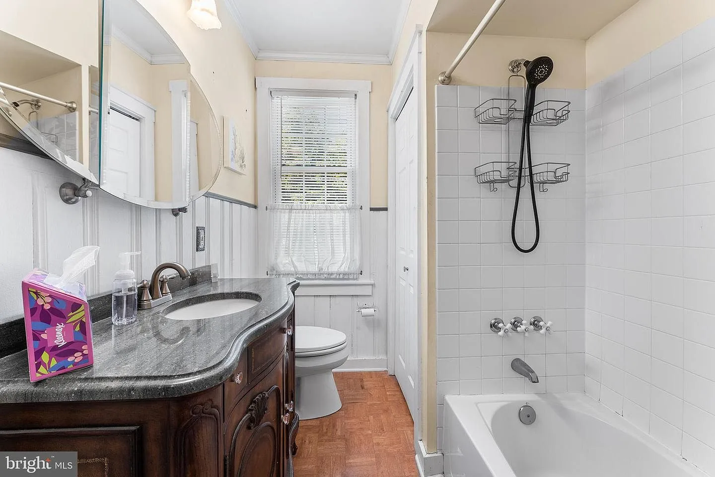 Bathroom with dark wood vanity, stone countertop, and subway tile