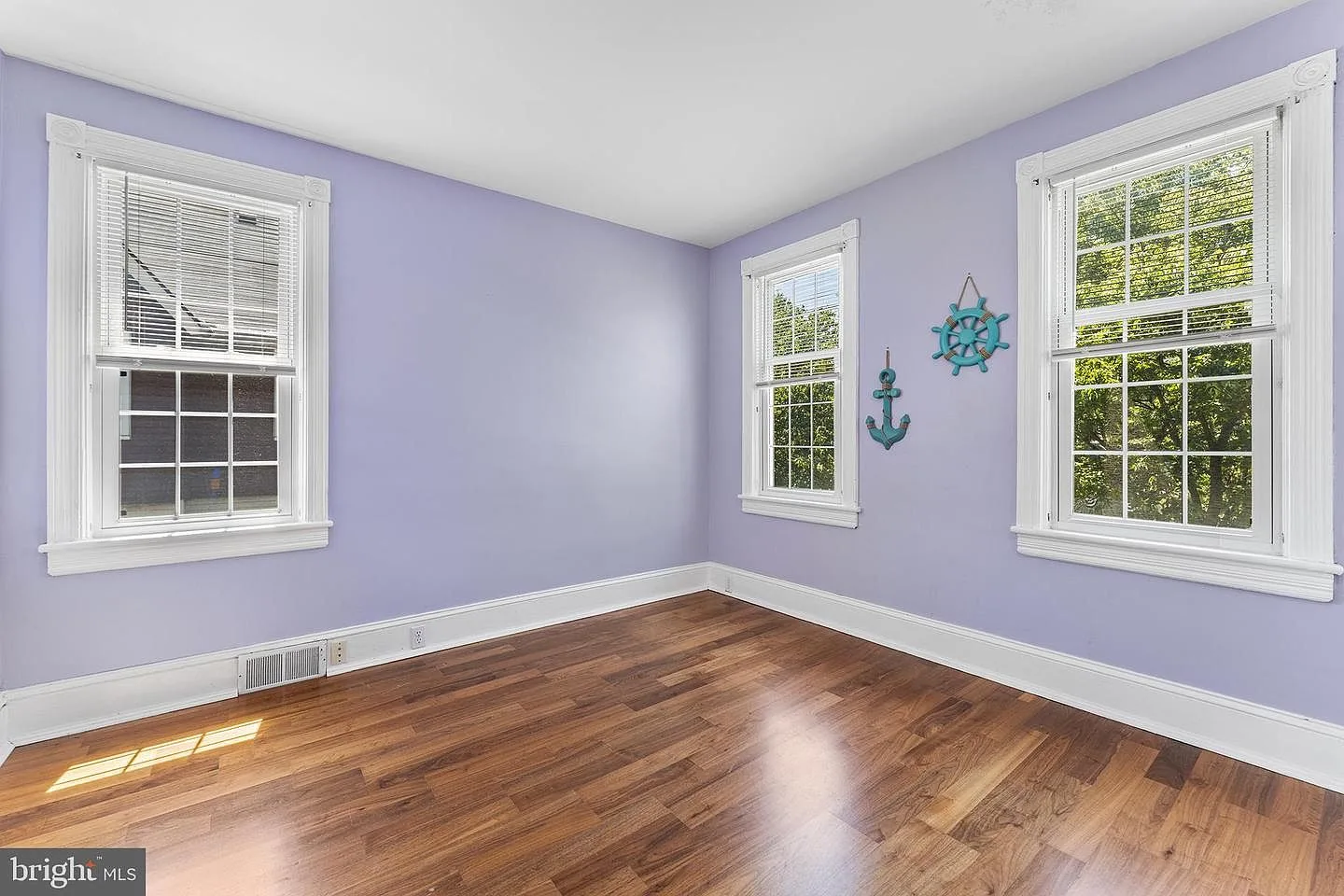Bedroom corner with light purple walls and natural daylight