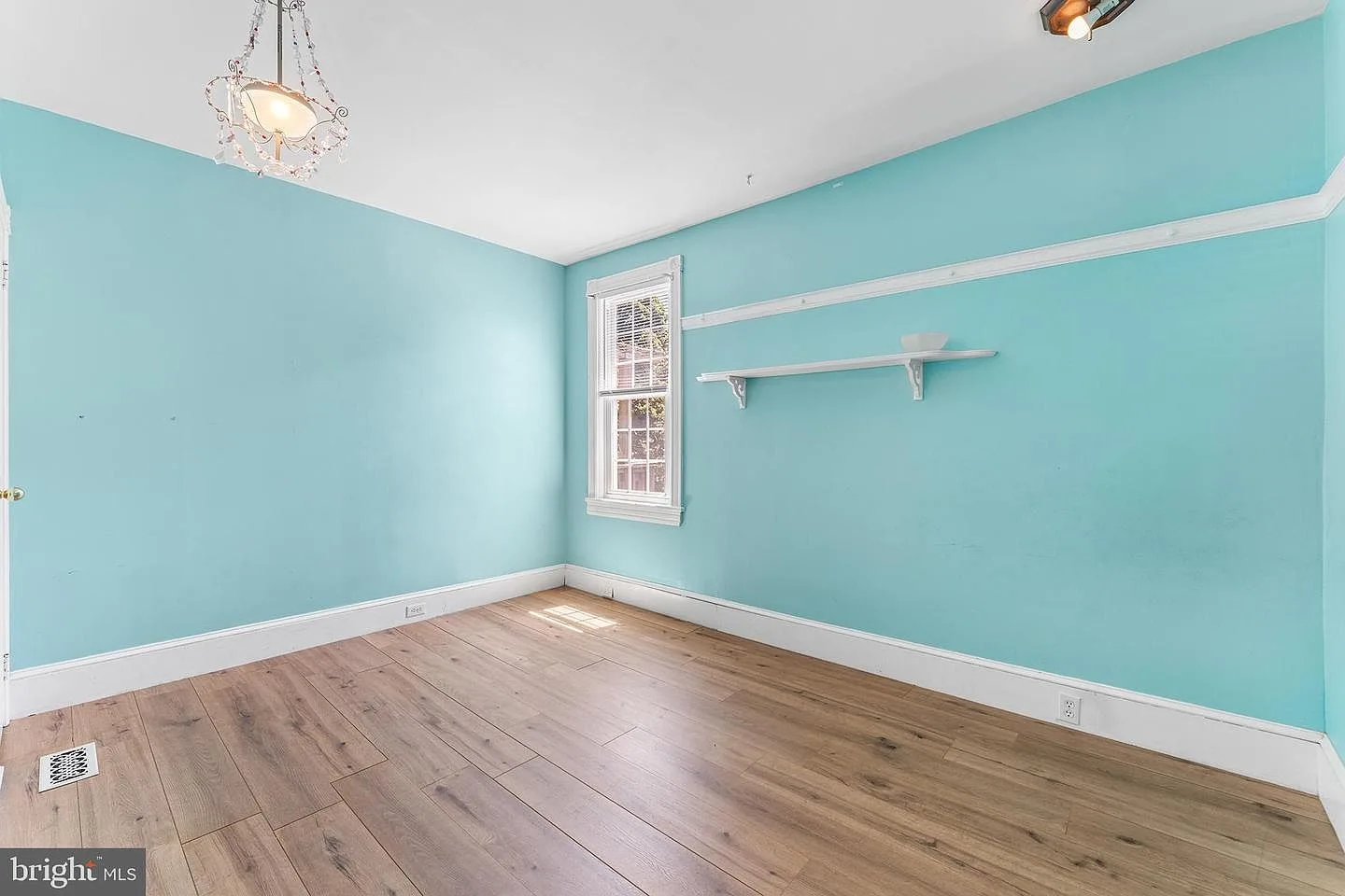 Bedroom with light blue walls, crown molding, and chair rail