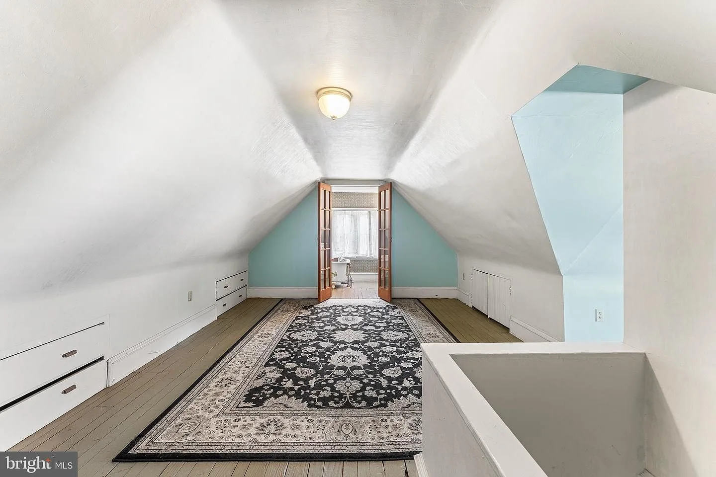 Finished attic space with sloped ceilings and built-in cabinetry