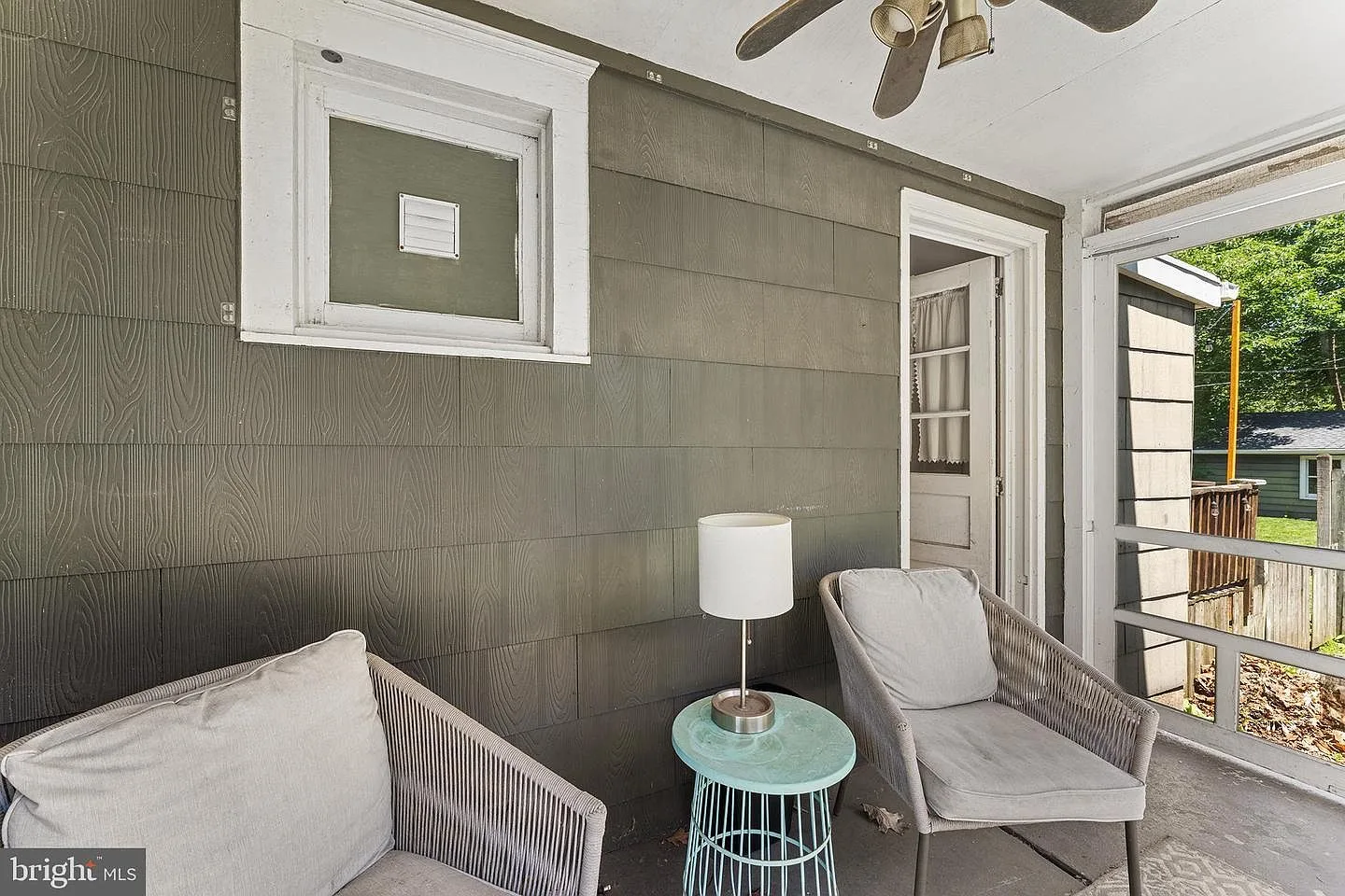 Screened porch with seating area and white trim