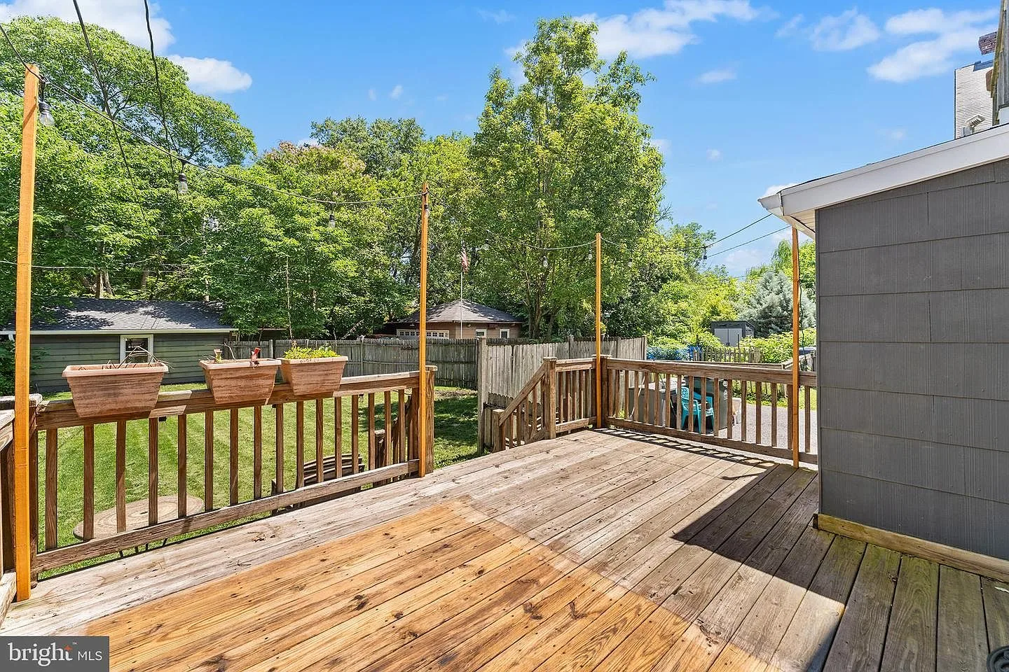 Backyard wood deck with string light poles