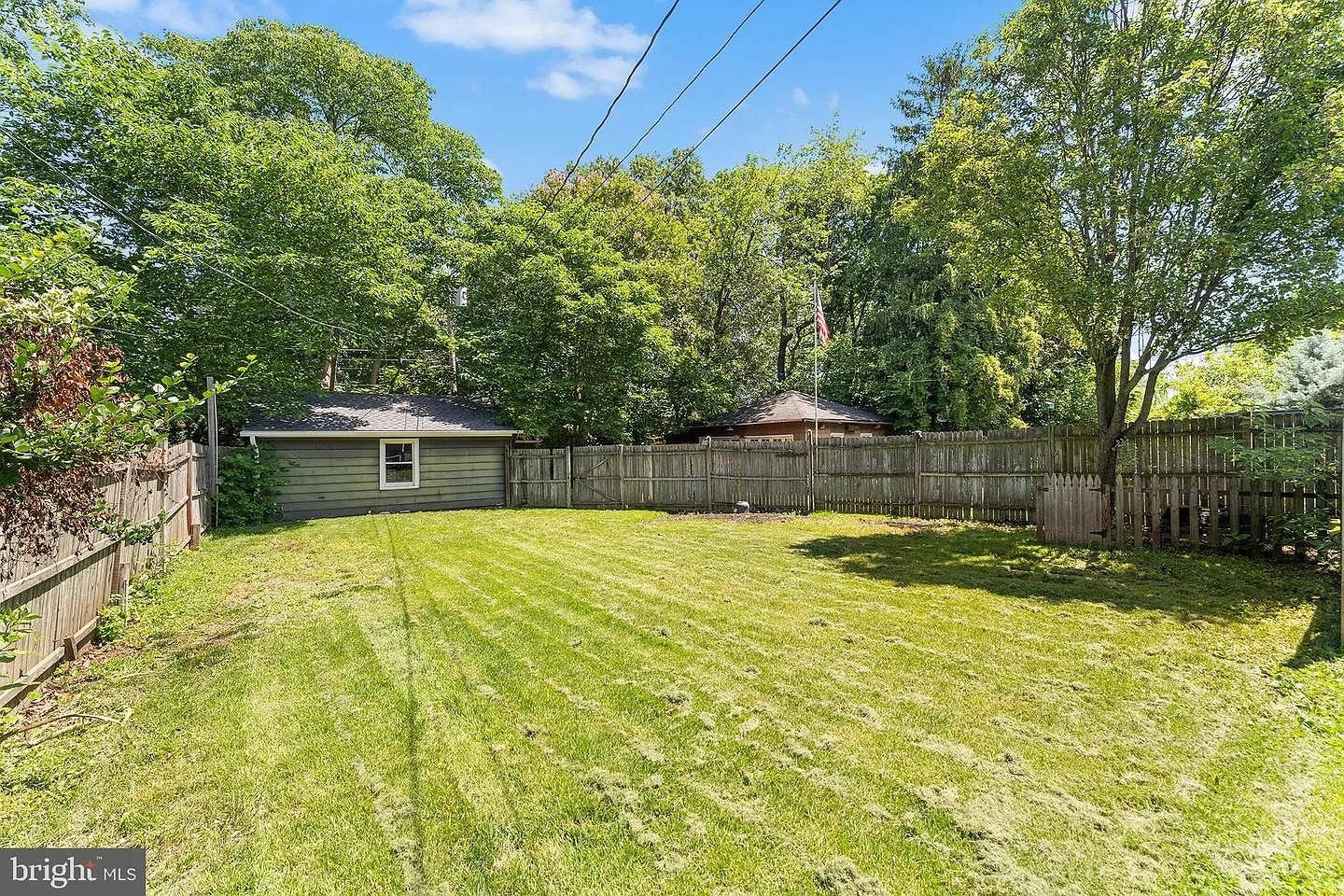 Spacious backyard with level lawn, wood fence, and detached garage