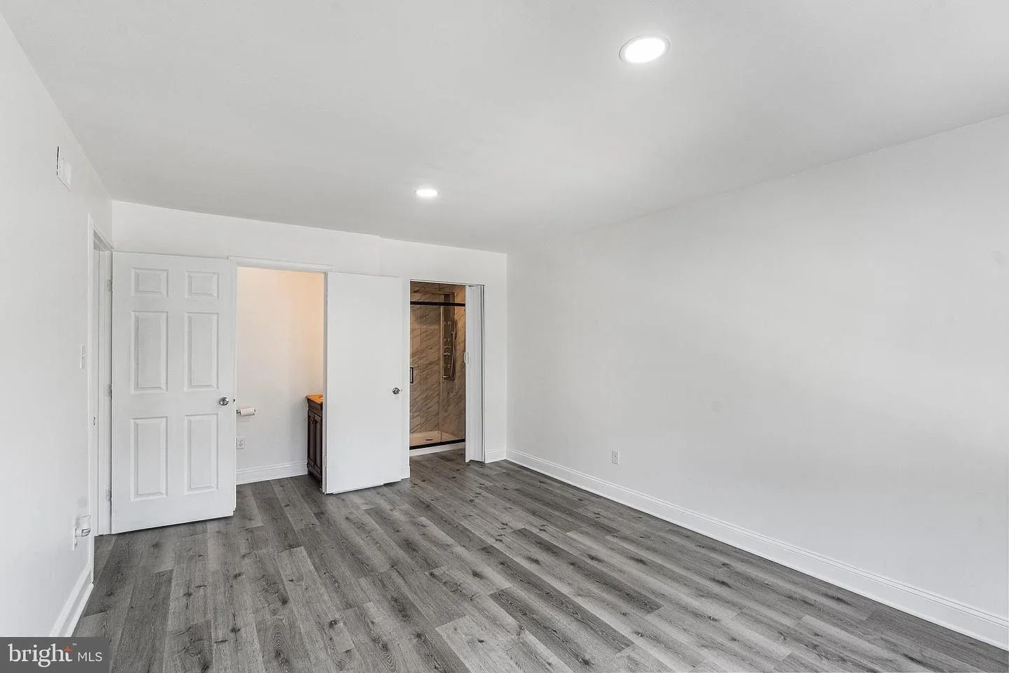 Vacant master bedroom with gray flooring and recessed ceiling lighting