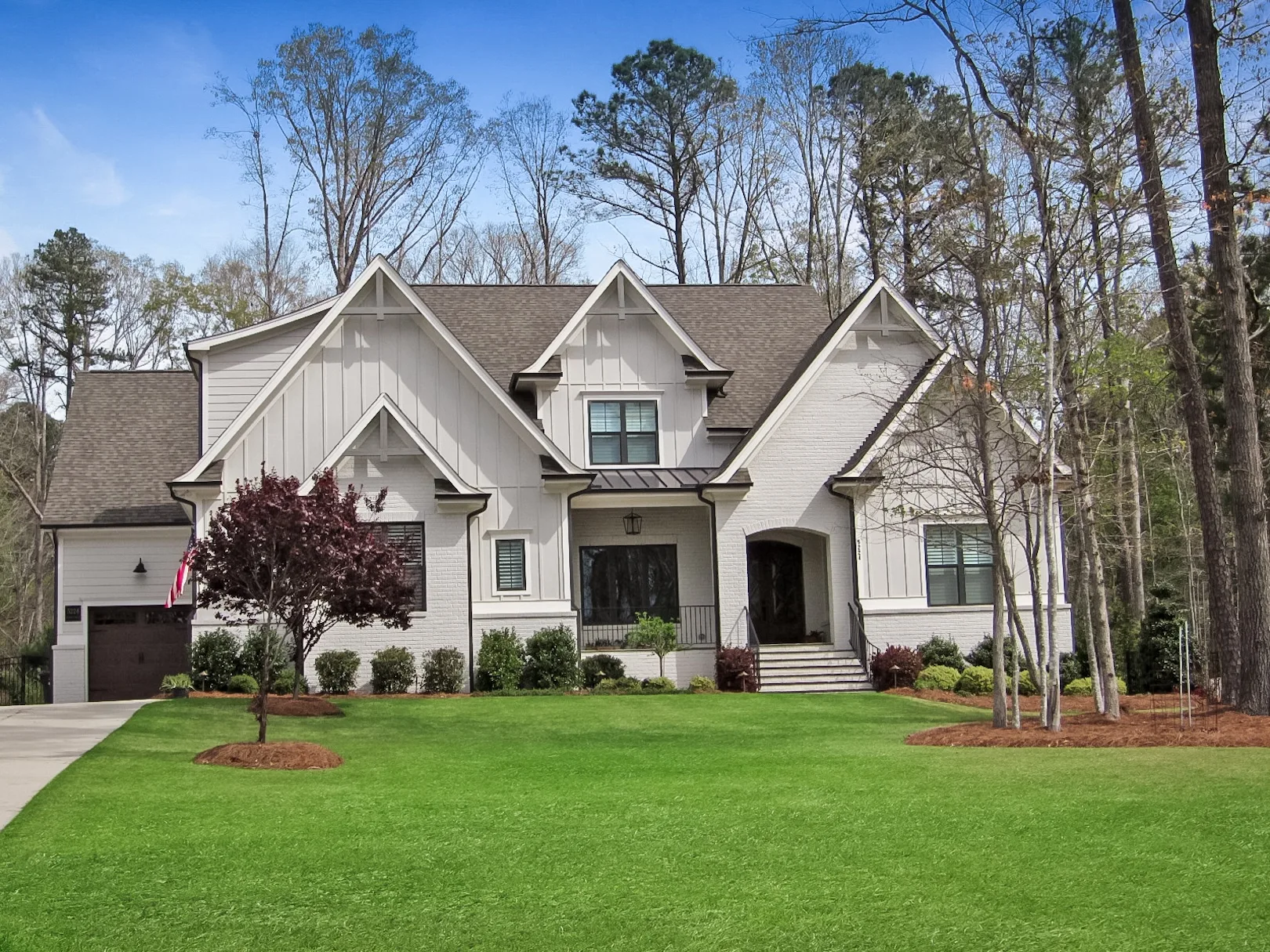 Grey brick farmhouse-style home with vertical siding in Cary, NC