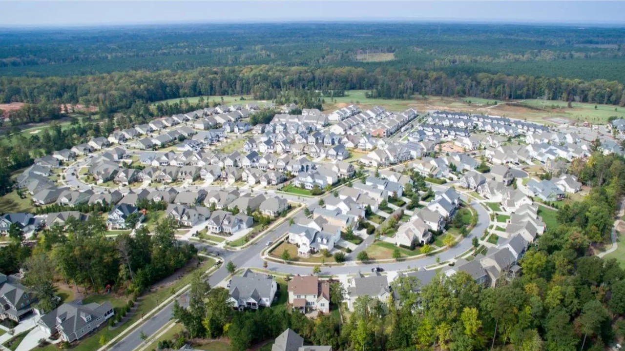 Aerial view of a suburban residential neighborhood in Cary, NC with traditional homes and winding streets