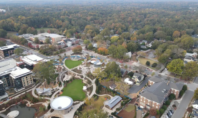 Aerial drone view of a public park in Cary, NC with paved pathways, lawn areas, and a circular pavilion