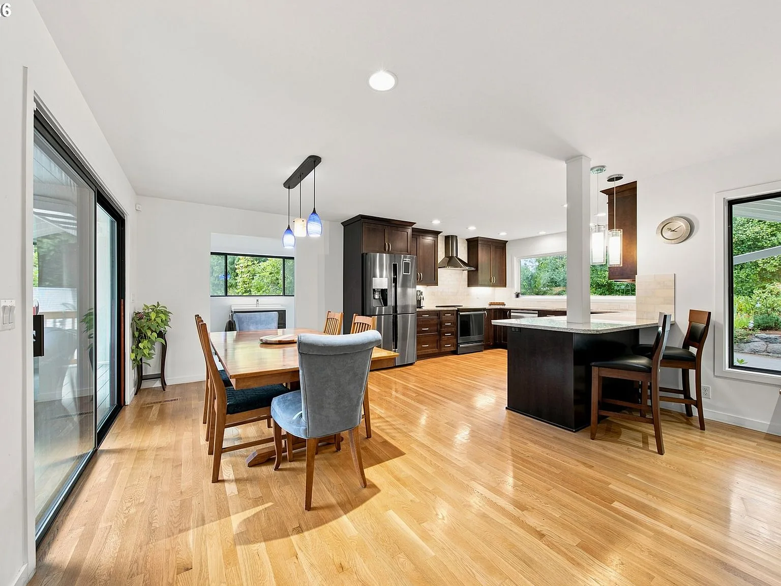 Kitchen and dining area with dark cabinetry and stainless steel appliances