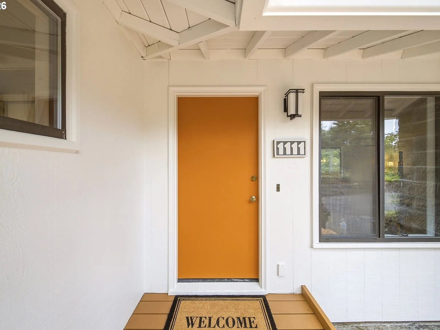 Front porch entryway with bright orange door