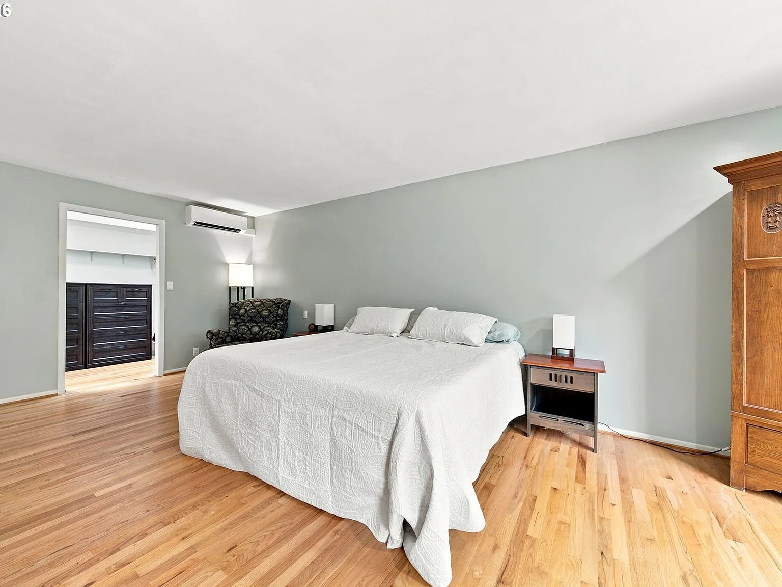 Primary bedroom with light hardwood floors and gray walls