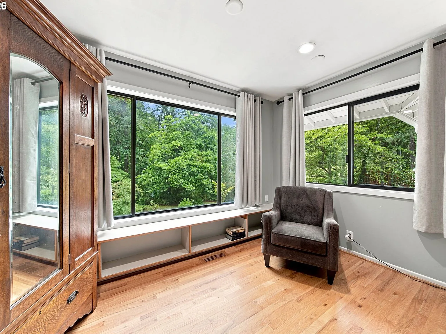 Bedroom with forest views through large windows