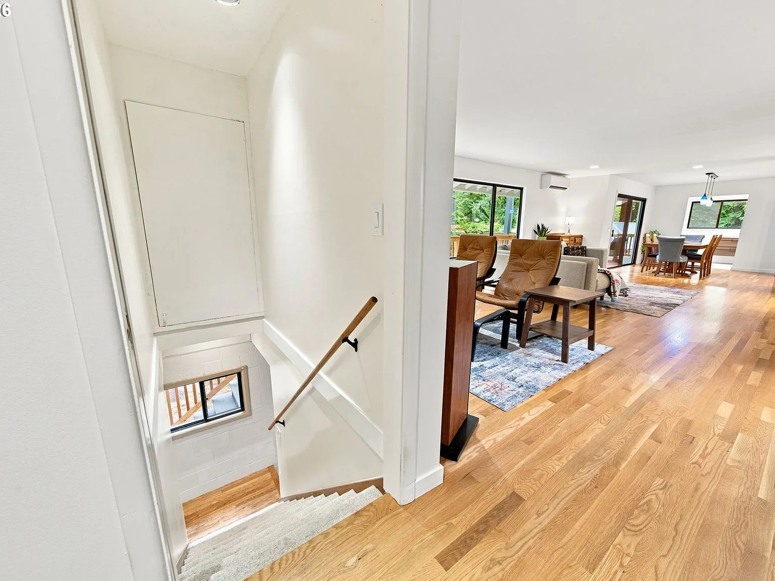 Staircase transitioning into open-concept living and dining area