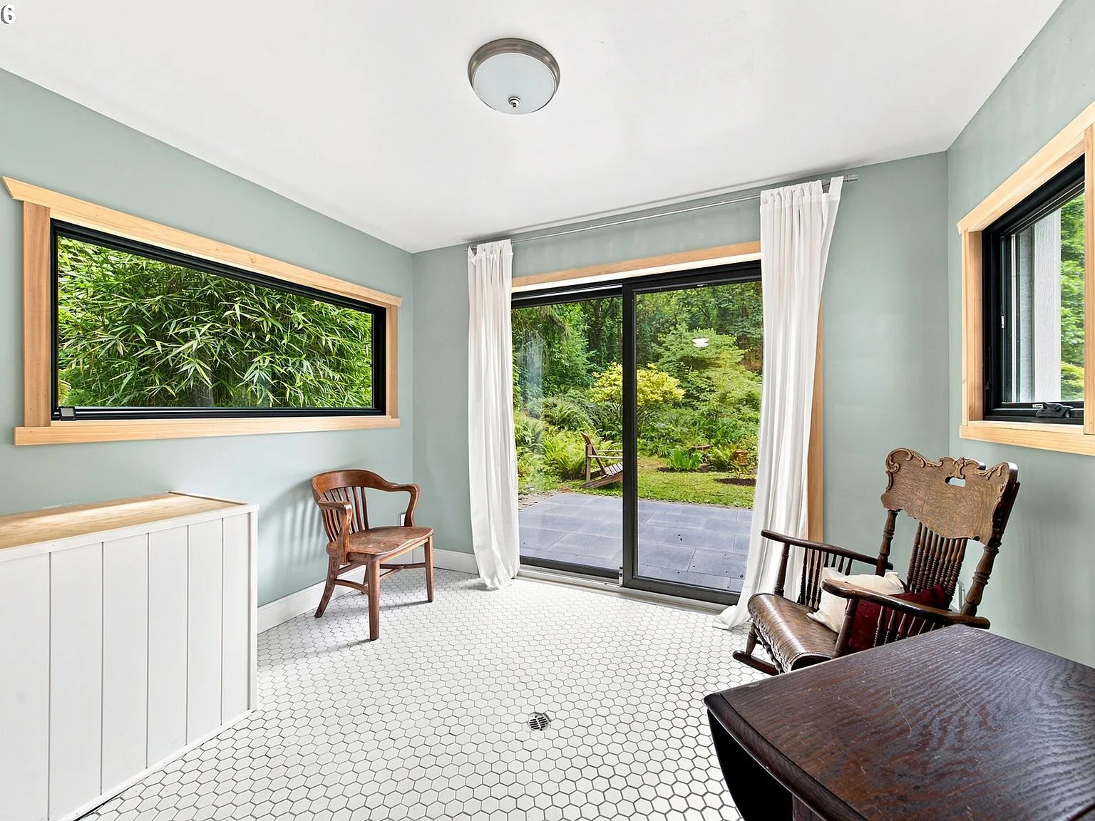 Sunroom with hexagonal tile flooring and garden views