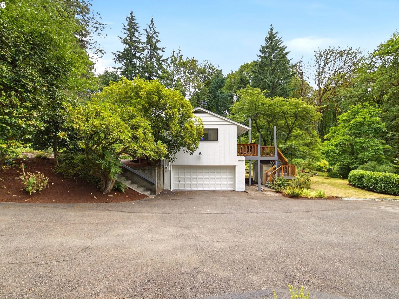 Attached garage and deck structure among mature trees