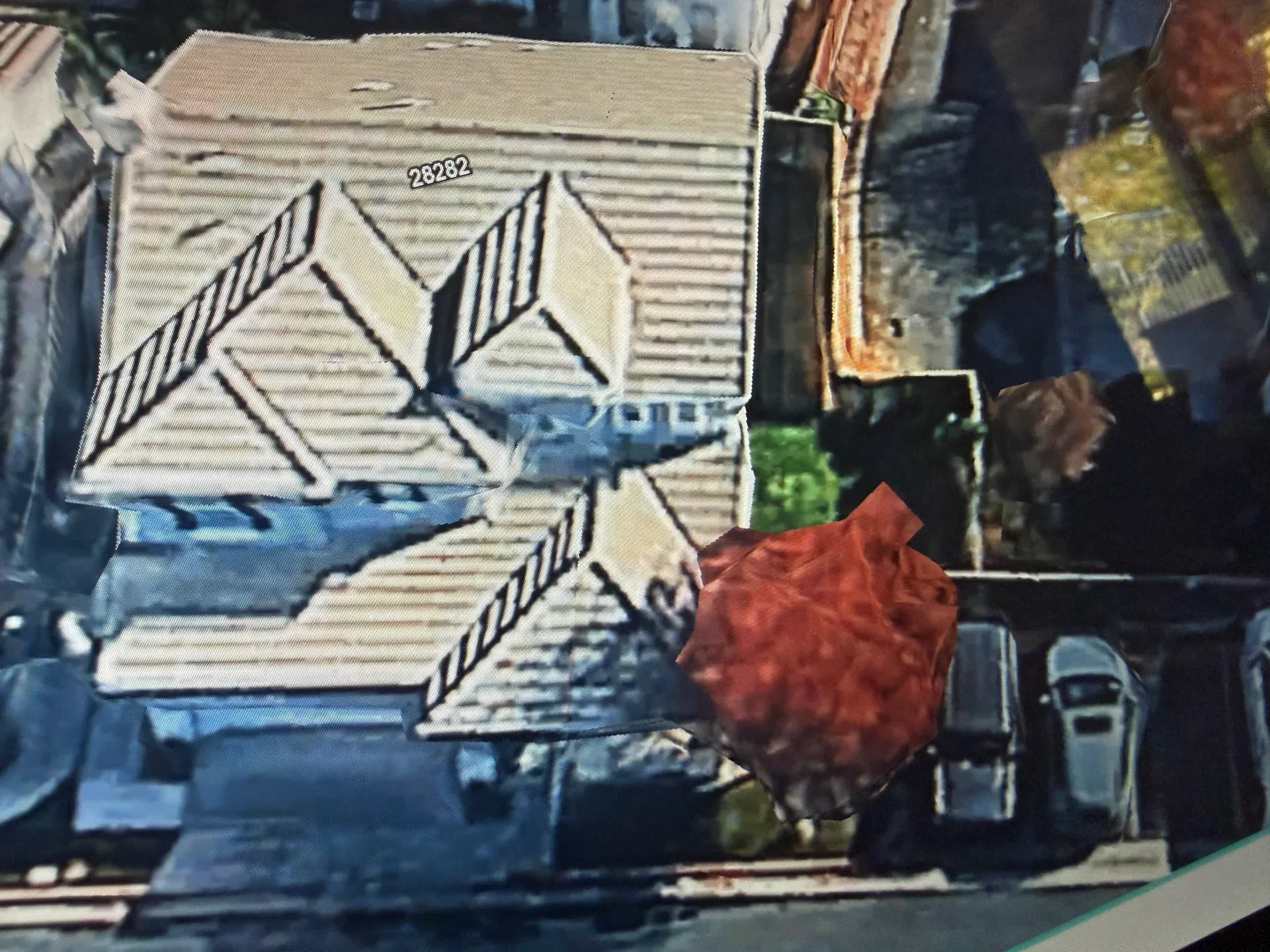 Aerial view of a single-family home with red tile roof and backyard