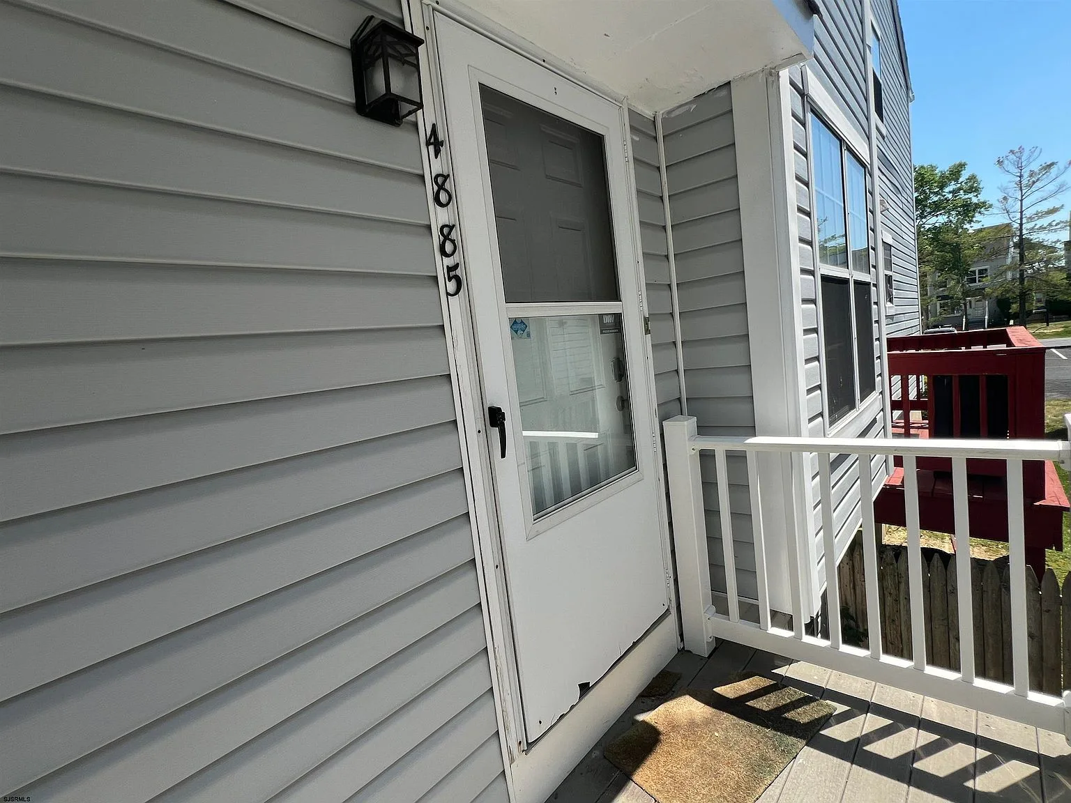 Front door entry with grey vinyl siding and white trim