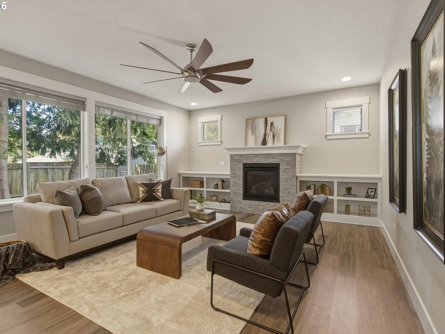 Living room with gas fireplace, built-in shelving, and tall ceilings
