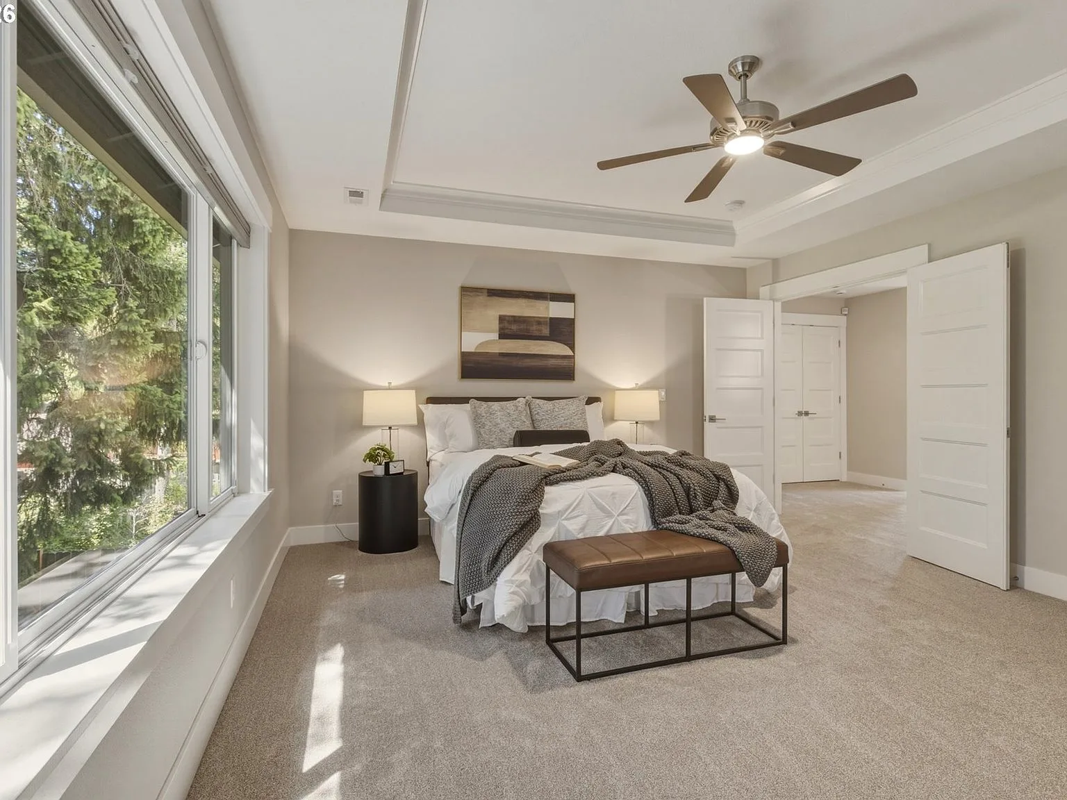 Primary bedroom with coffered ceiling and large windows