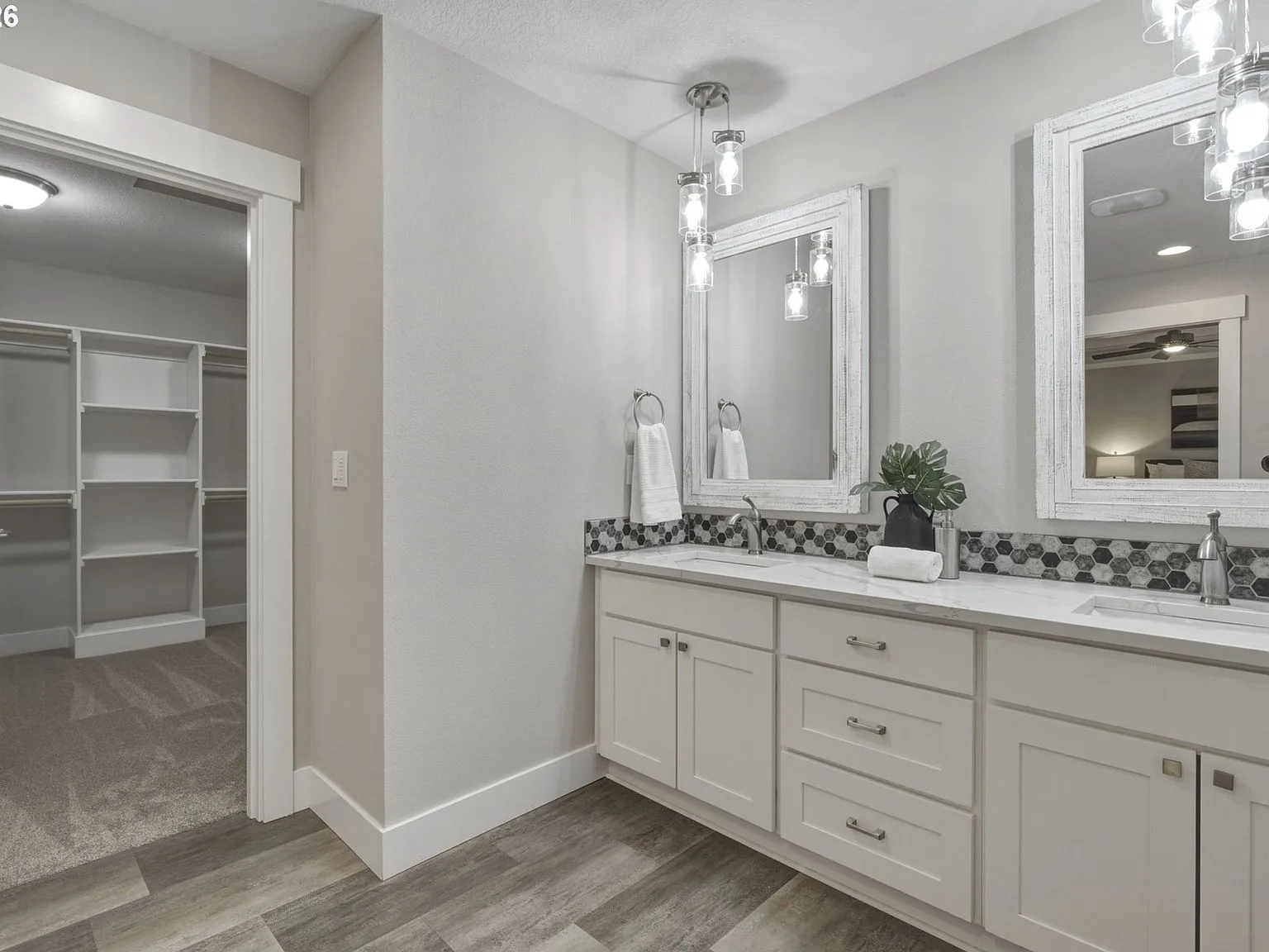 Primary bathroom dual vanity with geometric tile backsplash