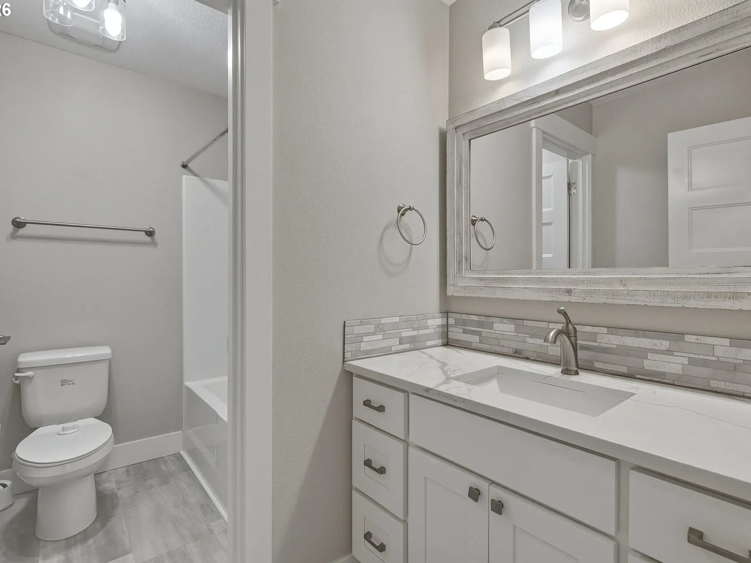 Guest bathroom with marble-look vanity countertop and mosaic tile backsplash