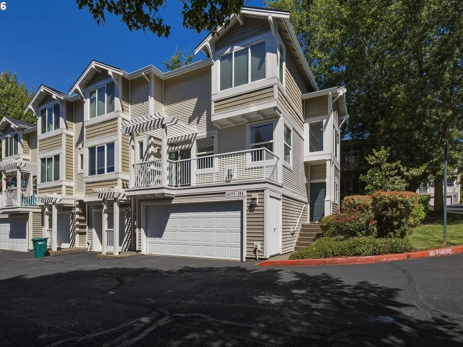 Street-level exterior view with tan siding and white trim