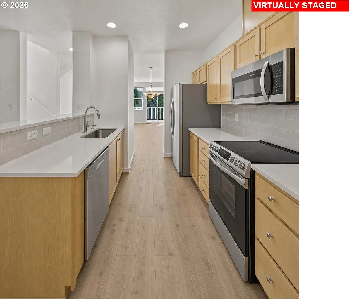 Modern galley kitchen with stainless steel appliances and quartz countertops