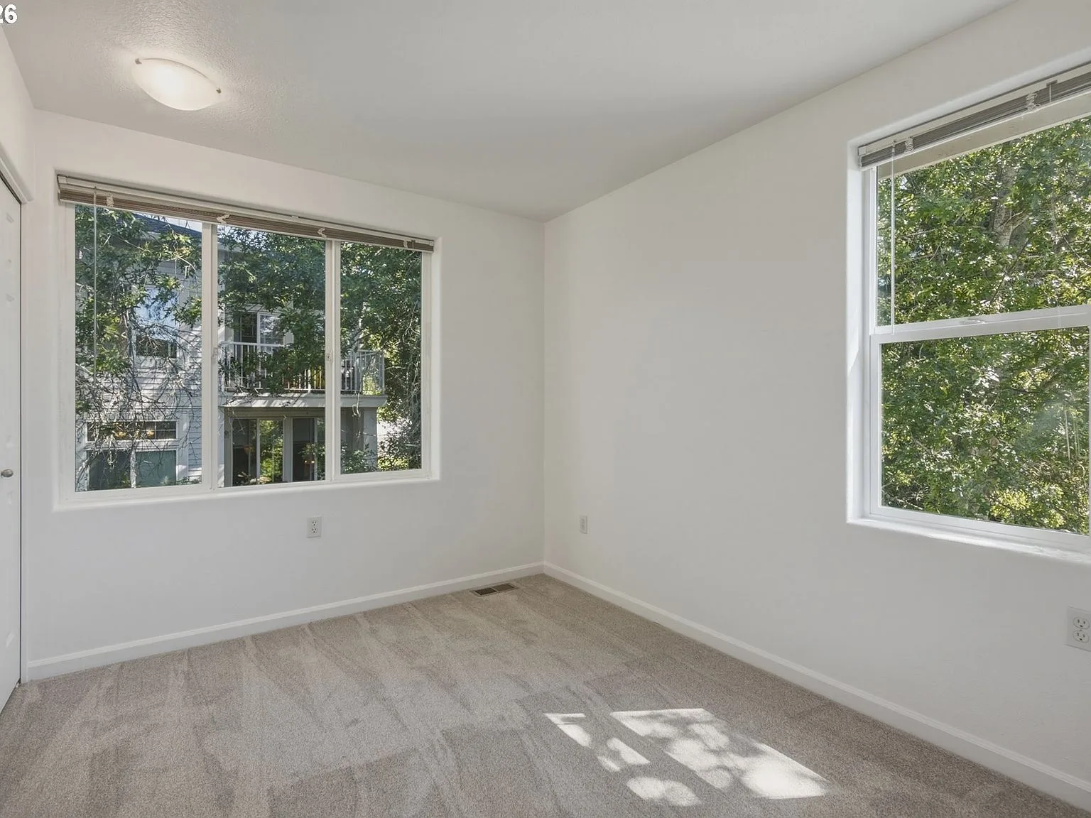 Second bedroom with carpet and natural light