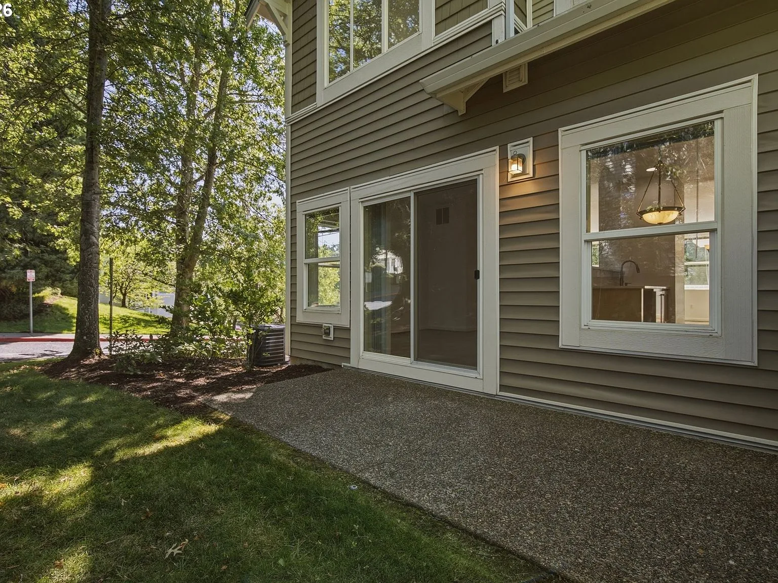 View of back patio area with trees and lawn