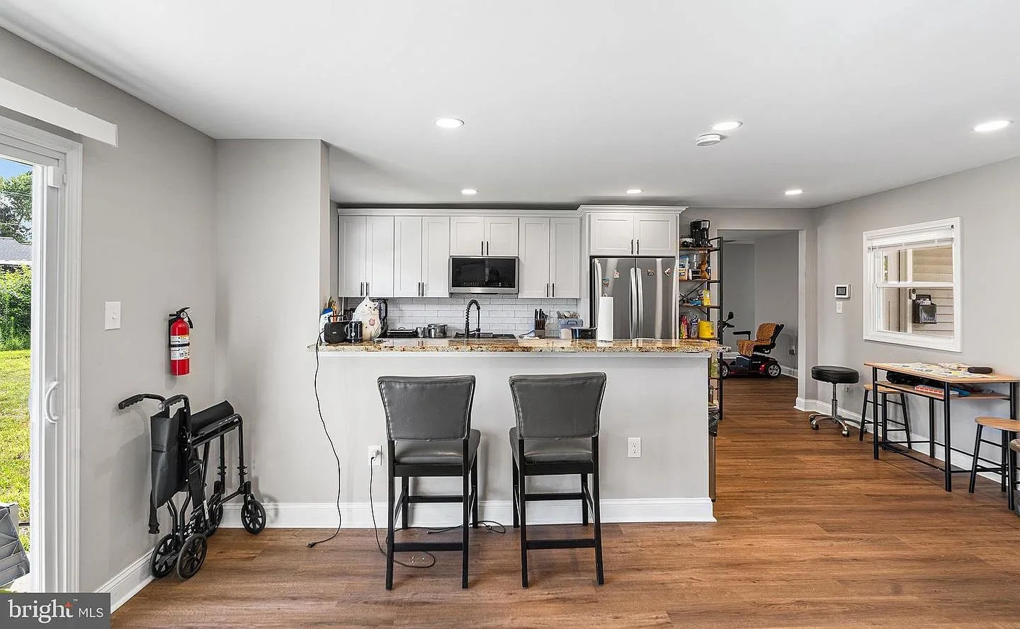 Wide-angle kitchen and dining room with sliding glass door and recessed lighting