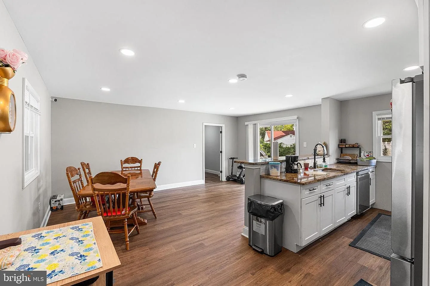 Kitchen and dining area with wood flooring and natural light