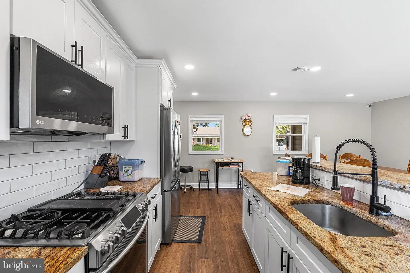 Kitchen with white cabinetry, granite countertops, and stainless steel appliances