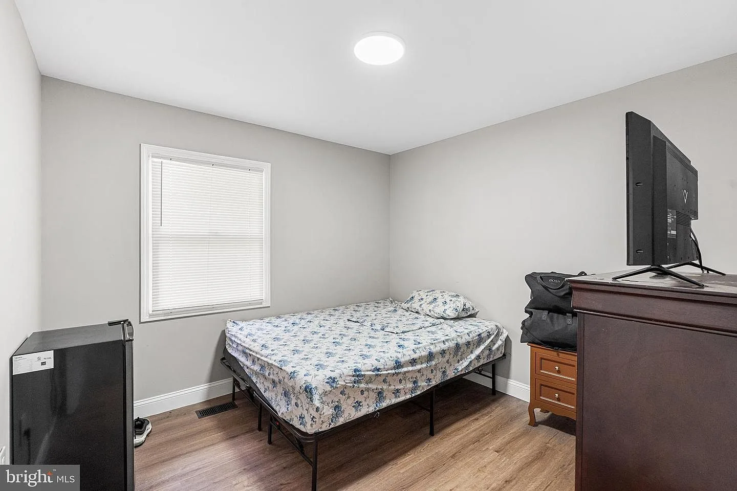 Bedroom with neutral walls, recessed ceiling lighting, and wood-look flooring