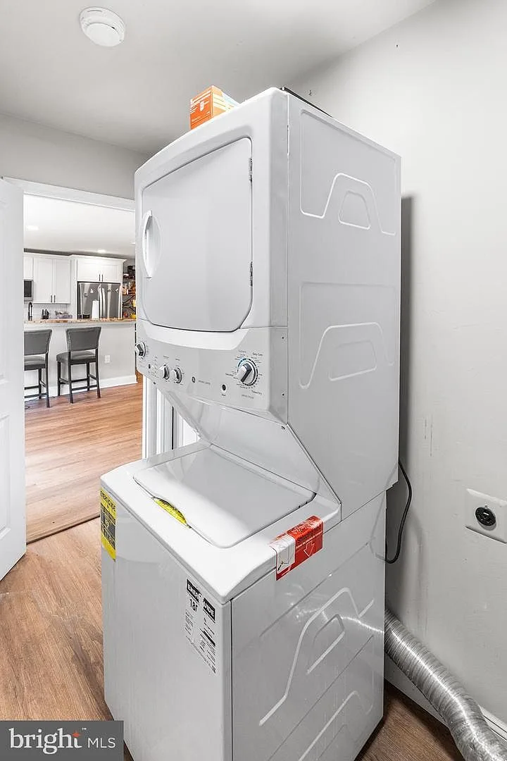 Laundry closet with stacked white washer and dryer unit