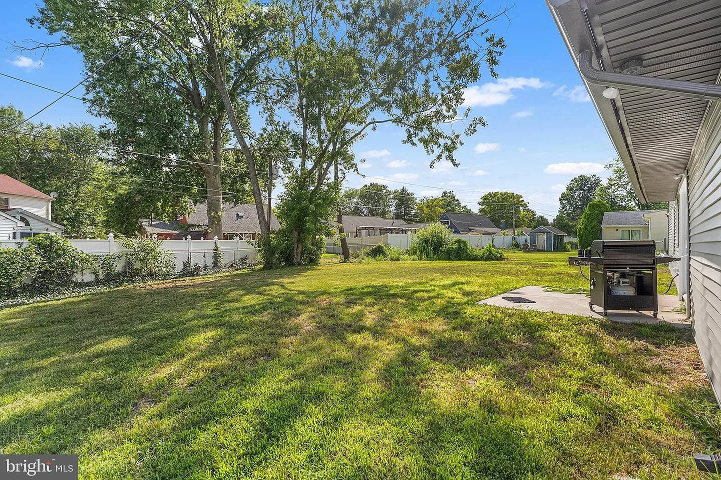 Backyard patio area with concrete pad and ranch home exterior