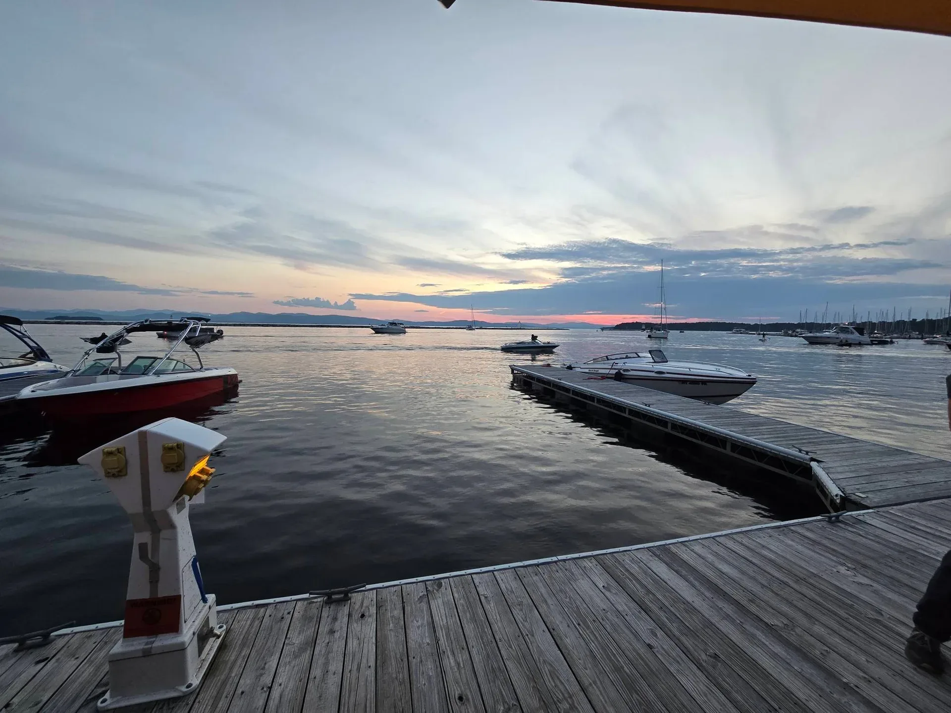 The Burlington marina at sunset with boats silhouetted against the evening sky