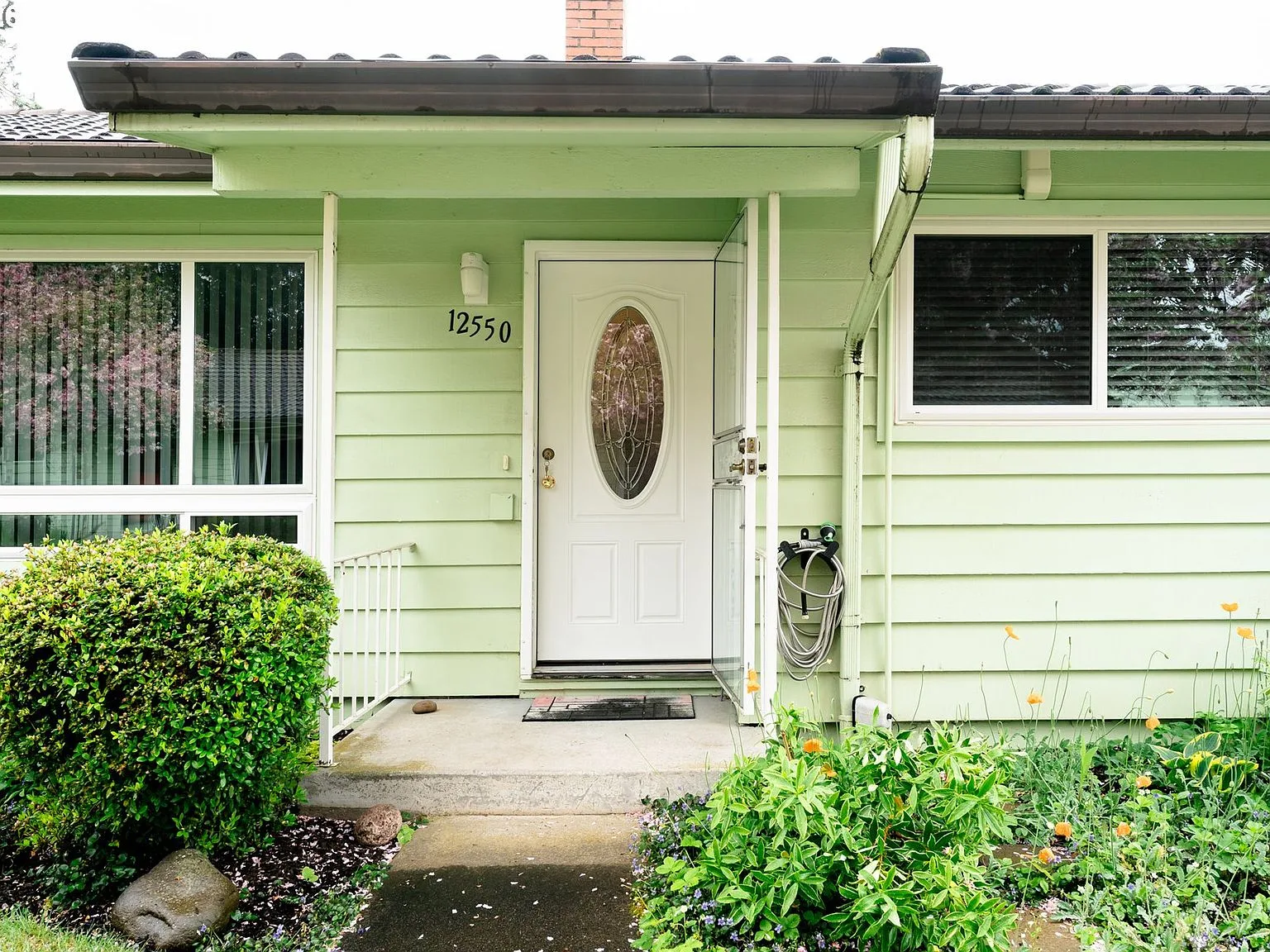 Straight-on view of the front entry with white door and oval glass insert