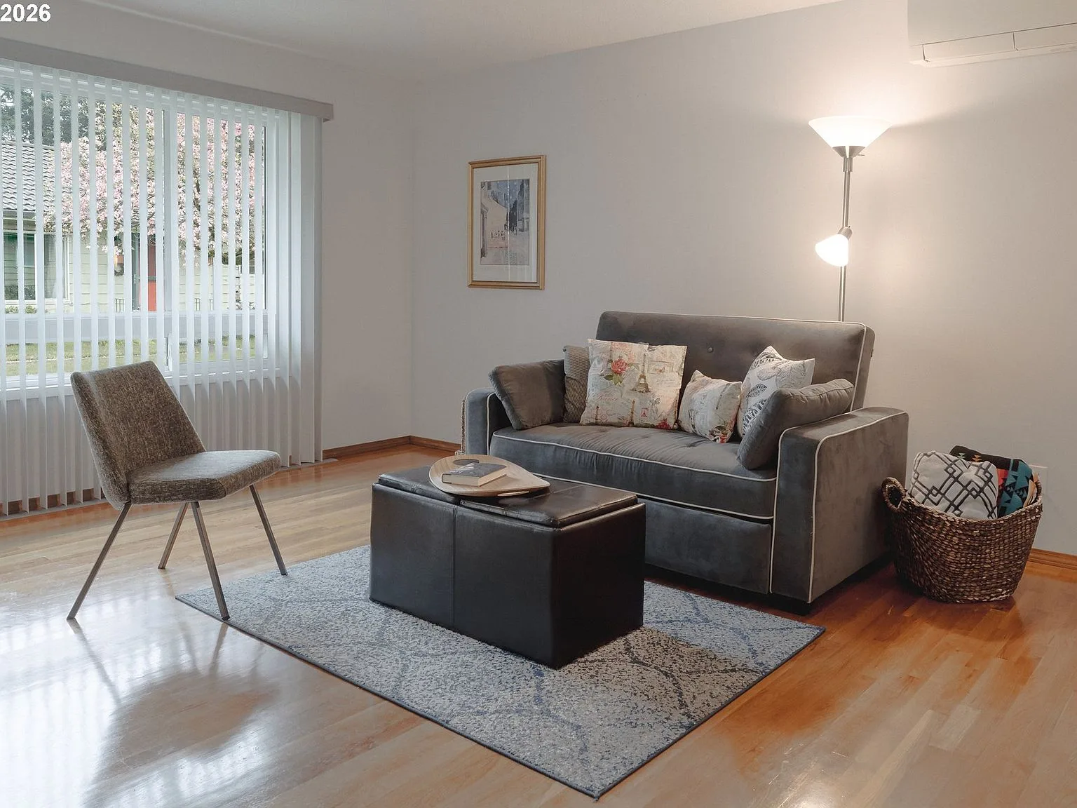 Living room seating area with hardwood floors and large window