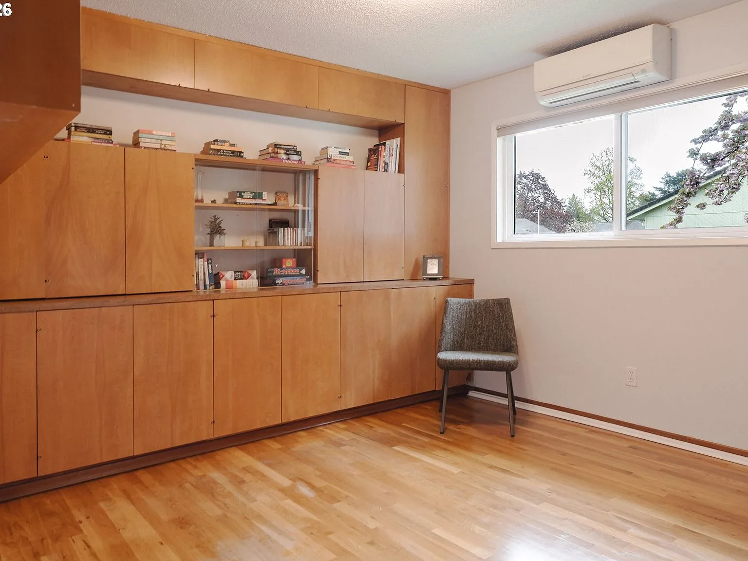 Bedroom with floor-to-ceiling built-in wooden shelving along the main wall
