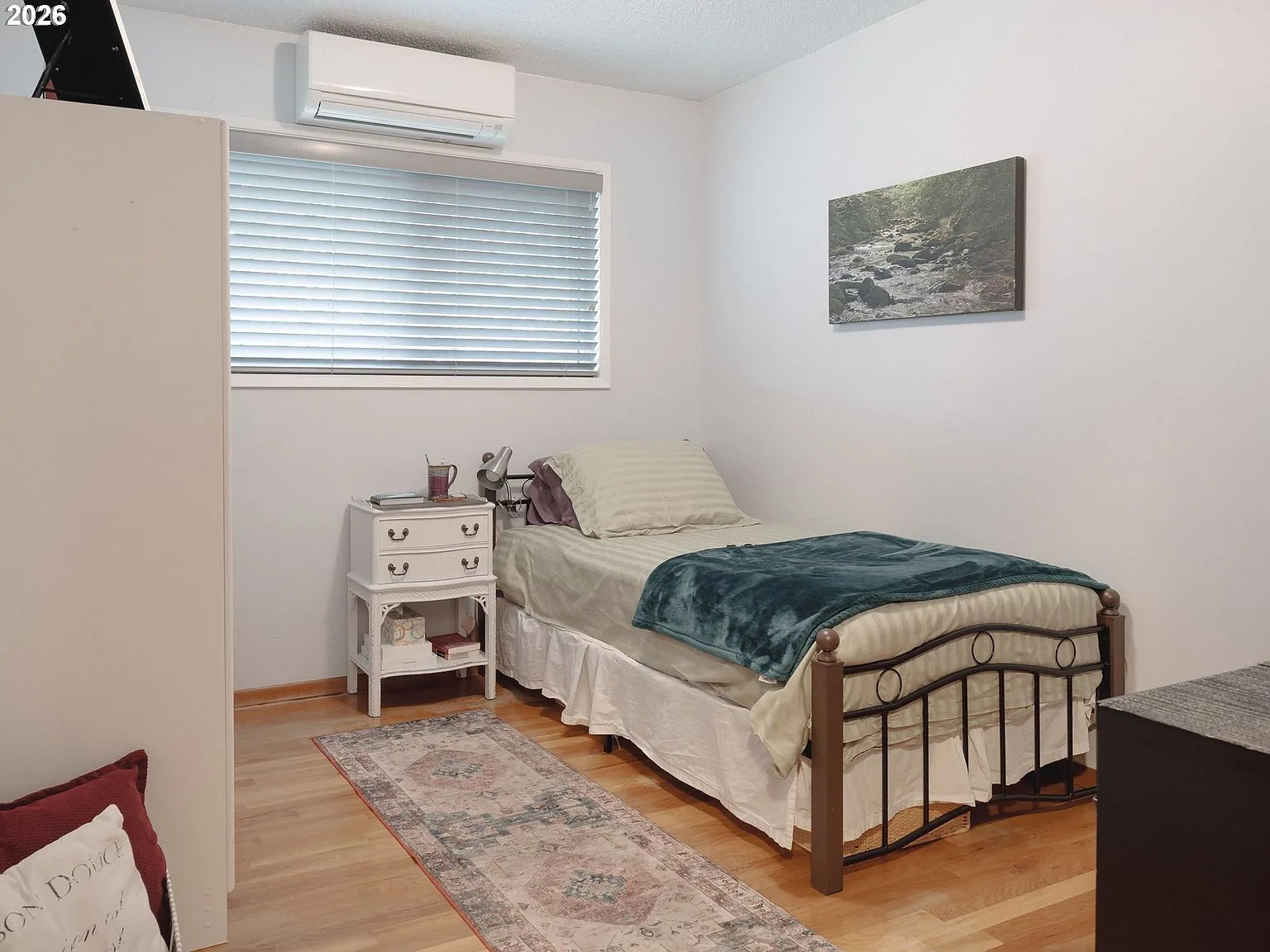 Guest bedroom with light gray walls and window with blinds