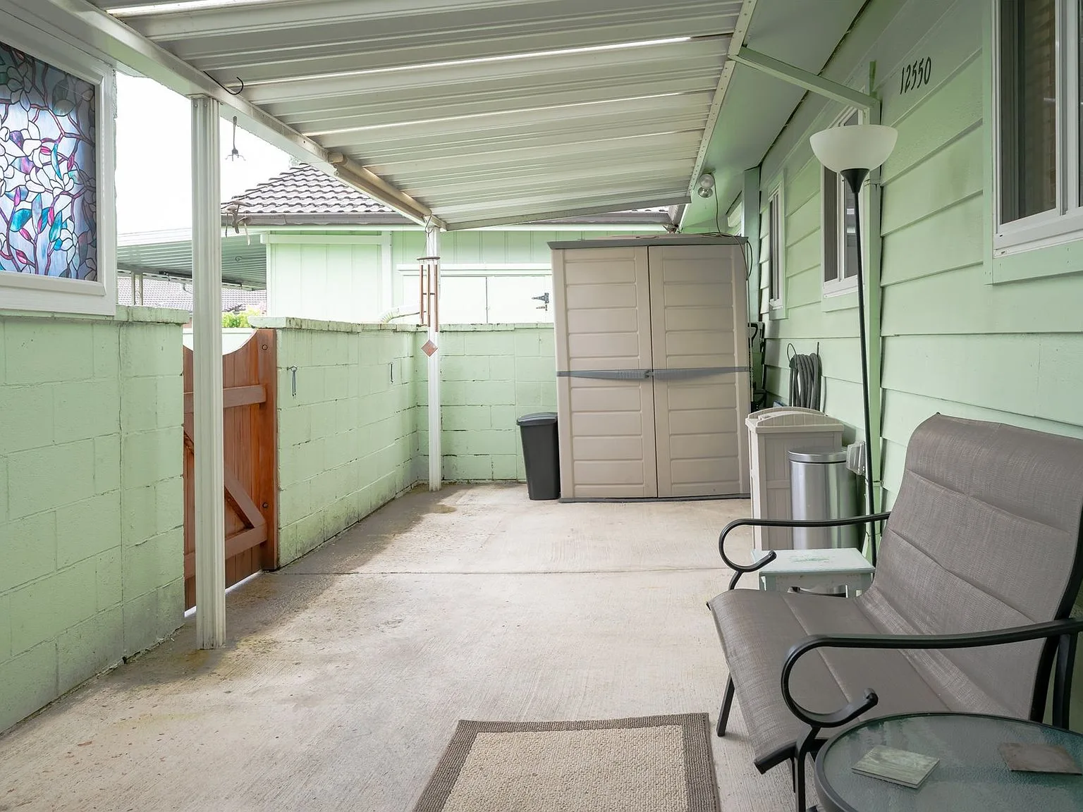 Covered private patio with concrete floor and painted cinder block walls