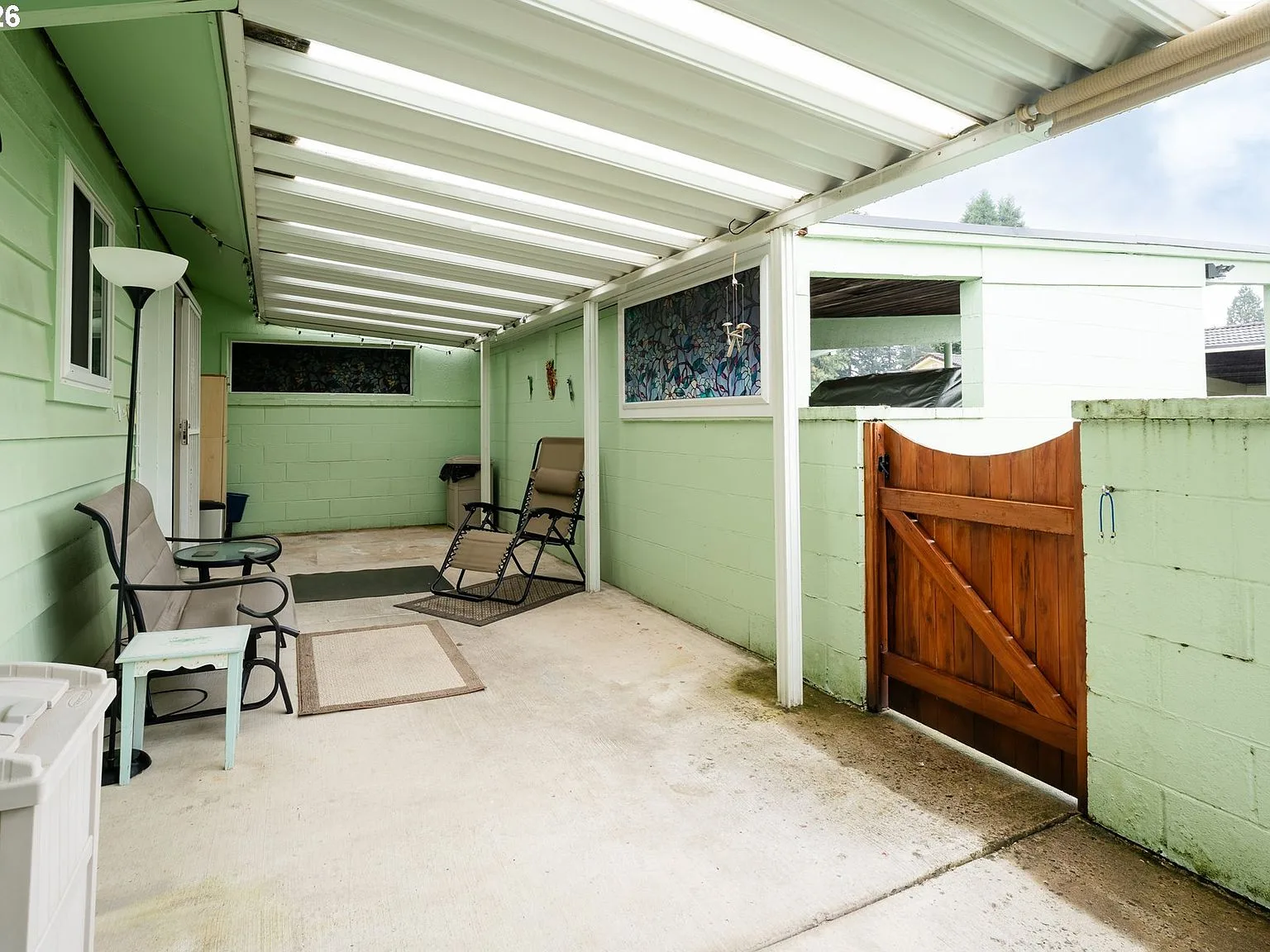 Covered patio area with corrugated metal roof and green painted walls