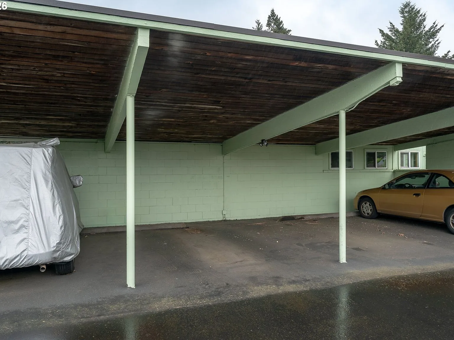 Covered carport parking bay with wood-plank ceiling