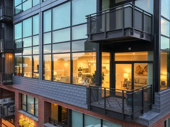 Modern glass and balcony facade of a downtown Durham condo building