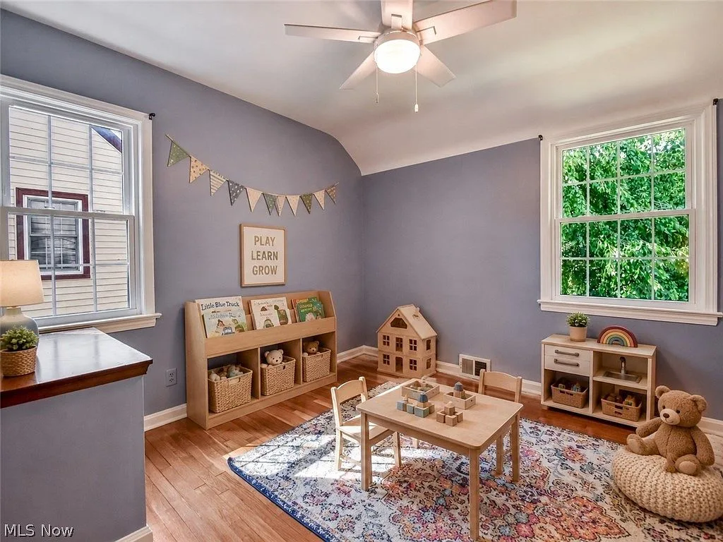 Third bedroom staged as a playroom with purple-grey walls