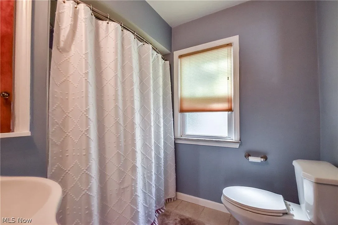 Bathroom with grey walls, white trim, and tub/shower