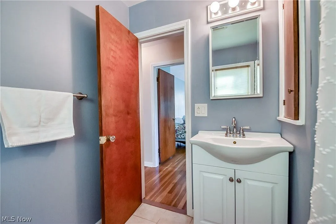 Bathroom with blue walls, white vanity, and medicine cabinet