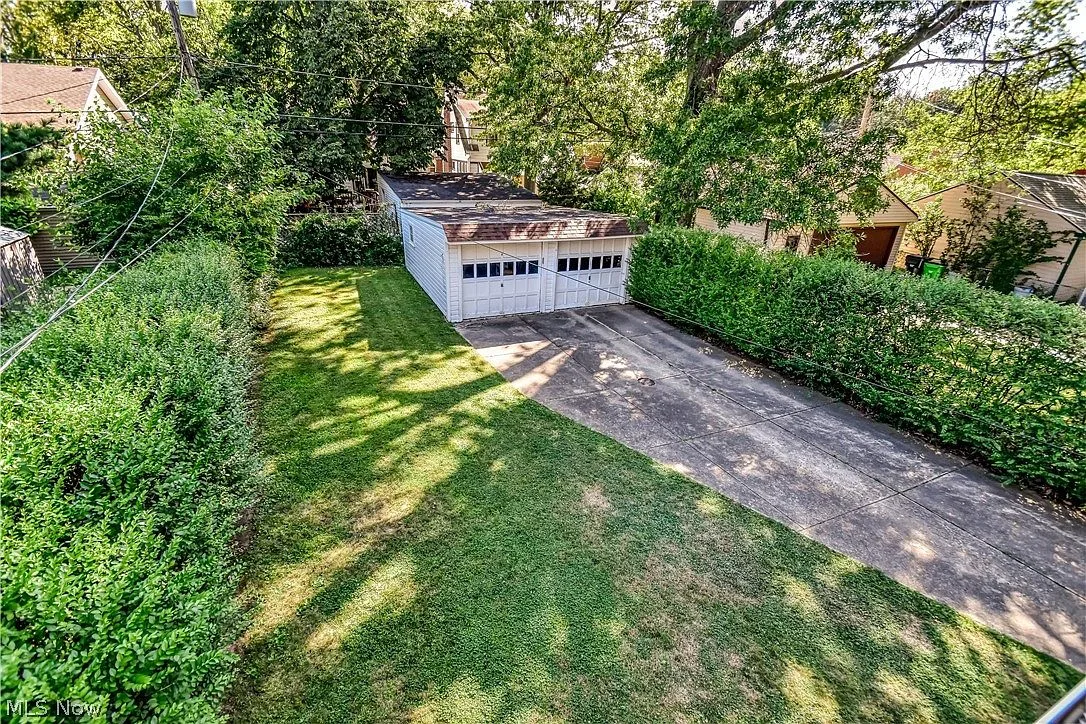 Private backyard with mature trees and detached two-car garage