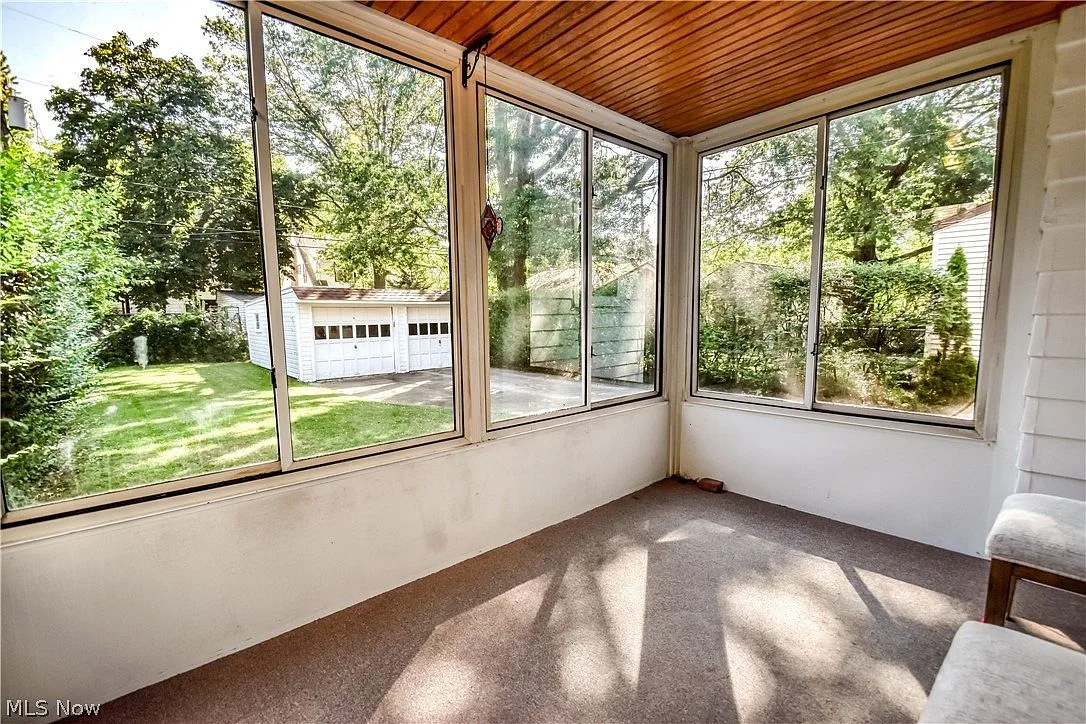 Enclosed sunroom with large windows overlooking the backyard