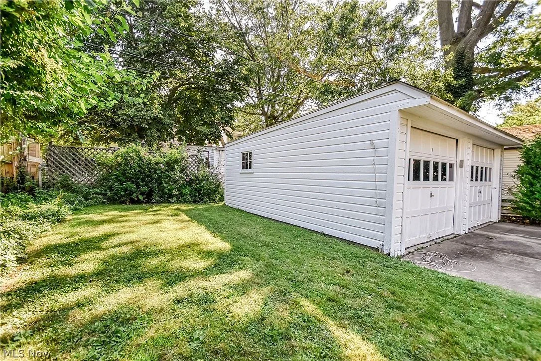 Detached garage with two overhead doors and privacy fencing